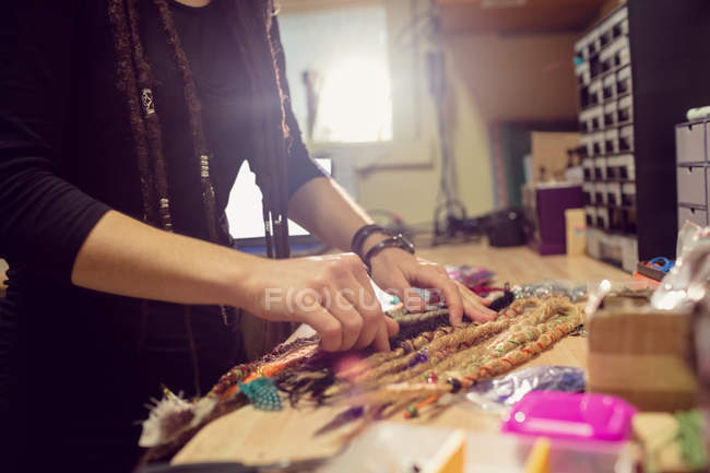 Женщина-парикмахер работает за столом в магазине дредов — стоковое фото