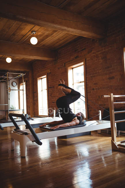 Mujer en forma practicando pilates en un gimnasio - foto de stock