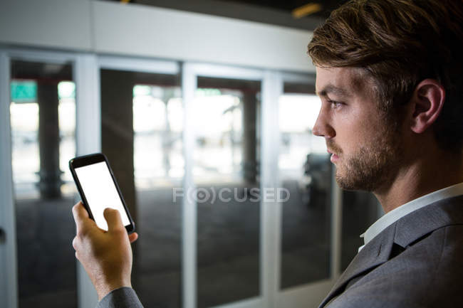 Крупним планом бізнесмен, використовуючи свій мобільний телефон в терміналі аеропорту — стокове фото