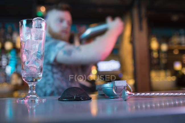 Barman preparando bebida com acessórios de bar no balcão no bar — Fotografia de Stock