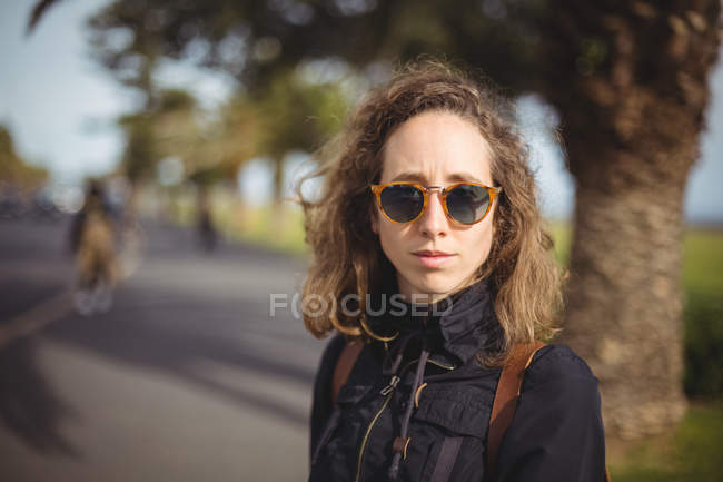 Gros plan de la femme avec des lunettes de soleil sur la route de la ville — Photo de stock
