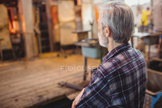 Glassblower standing at glassblowing factory — Stock Photo