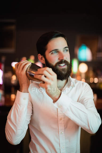 Barista sorridente scuotendo lo shaker al bar — Foto stock