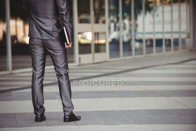 Vista ritagliata di uomo d'affari con diario in piedi nel campus ufficio — Foto stock