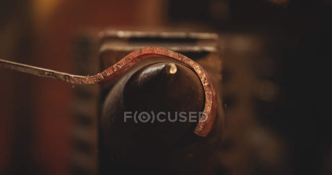 Close-up of blacksmith holding red hot metal horseshoe with tongs on anvil at work shop — Stock Photo