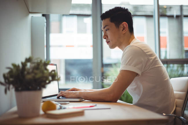 Dirigeant d'entreprise travaillant sur un ordinateur portable au bureau — Photo de stock