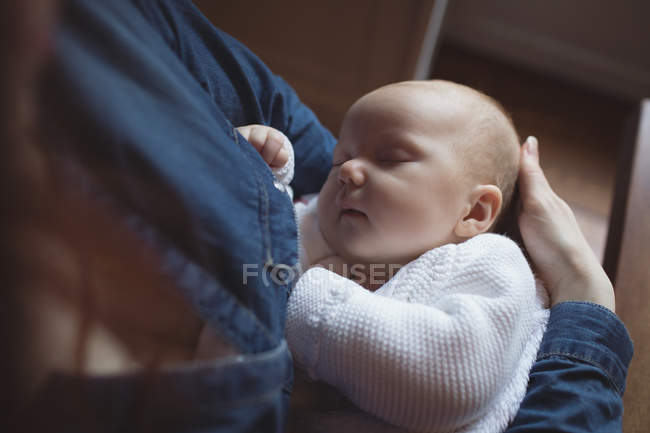 Крупним планом мати тримає сплячу дитину в руках — стокове фото