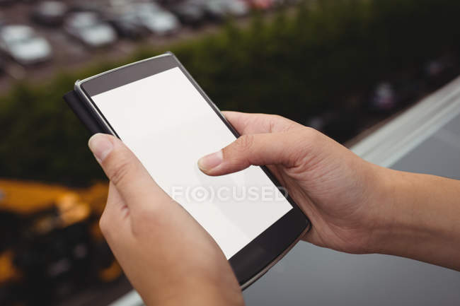 Close-up of businesswoman hands using mobile phone at office balcony — Stock Photo