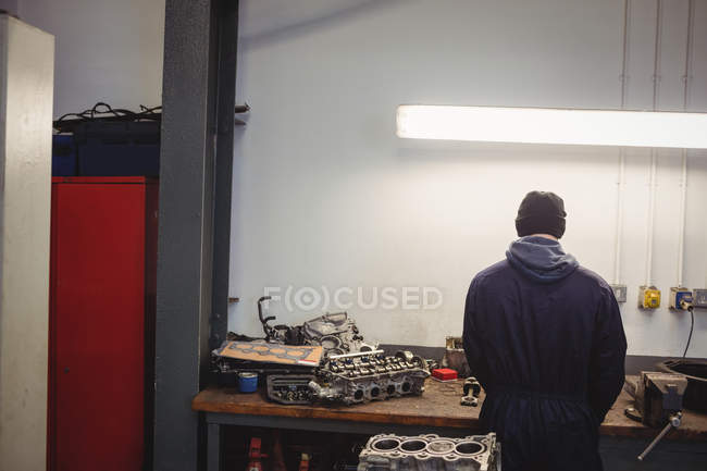 Vista trasera del mecánico trabajando en garaje de reparación - foto de stock