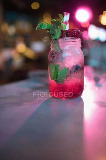Close-up de coquetel vermelho em frasco de vidro no balcão no bar — Fotografia de Stock