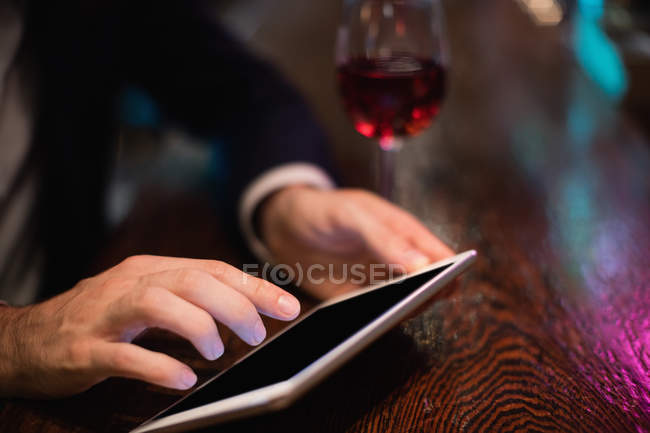 Uomo d'affari che utilizza tablet digitale nel bancone del bar al bar — Foto stock