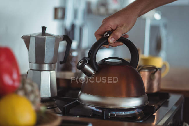 Préparation du thé dans une tasse de thé sur la cuisinière dans la cuisine — Photo de stock
