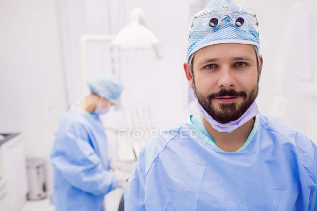 Retrato de dentista sorrindo na câmera da clínica odontológica — Fotografia de Stock