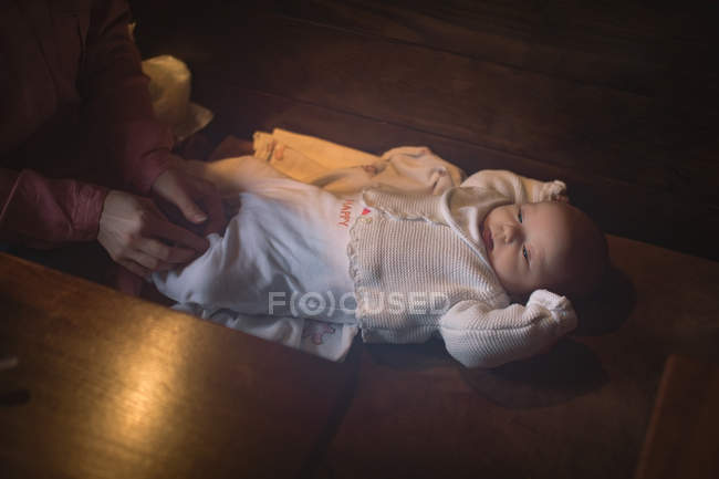 Mother changing diaper of infant daughter — Stock Photo