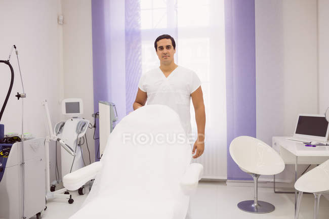Вид спереду чоловічий дерматолог стоїть у клініці — стокове фото
