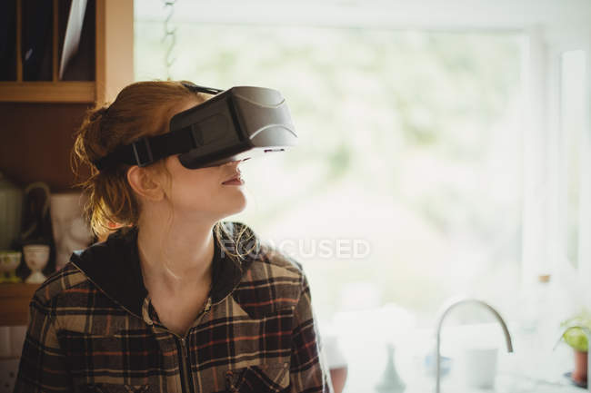 Жінка відчуває гарнітуру віртуальної реальності на кухні вдома — стокове фото