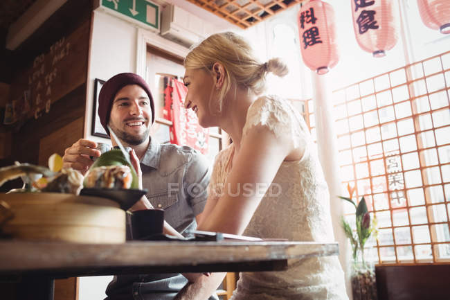 Pareja interactuando entre sí mientras toma el té en el restaurante - foto de stock