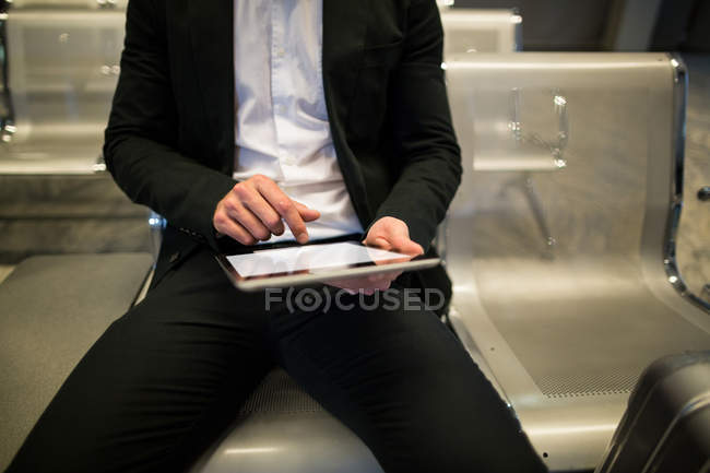 Milieu de la section de l'homme d'affaires en utilisant une tablette numérique à l'aéroport — Photo de stock