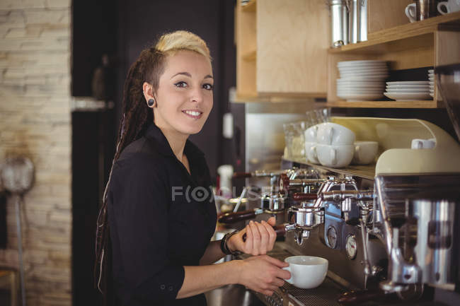 Портрет усміхненої офіціантки готує чашку кави в кафе — стокове фото