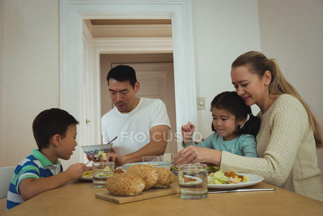 Famiglia felice che mangia sul tavolo da pranzo a casa — Foto stock