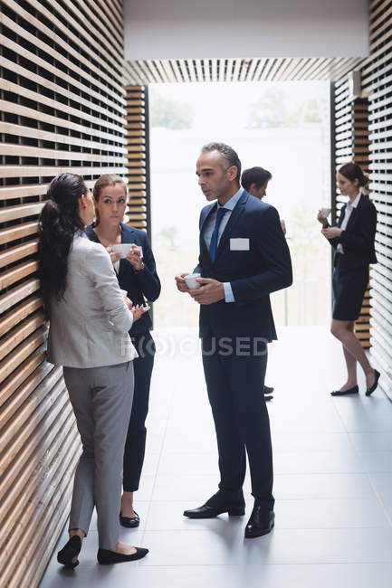 Uomini d'affari che prendono il tè e interagiscono durante la pausa in ufficio — Foto stock