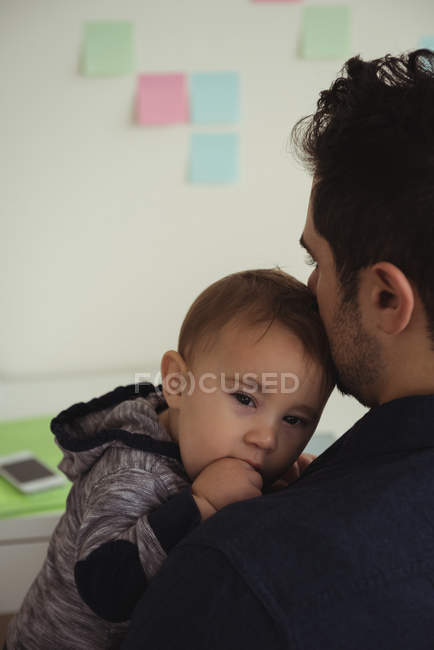 Primer plano del padre sosteniendo al bebé recién nacido en casa - foto de stock