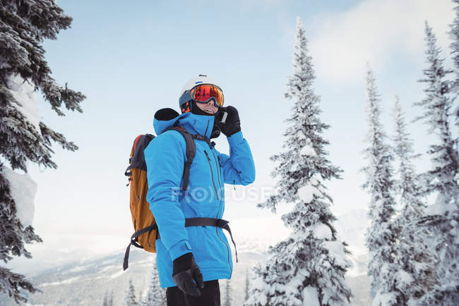 Esqui falando no telefone celular na neve paisagem coberta — Fotografia de Stock