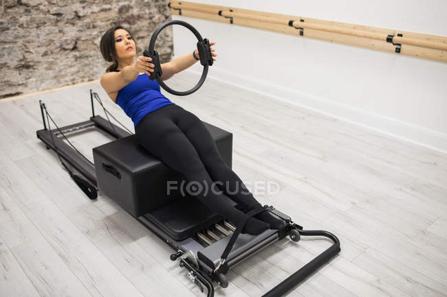 Femme faisant de l'exercice avec pilates anneau dans la salle de gym — Photo de stock