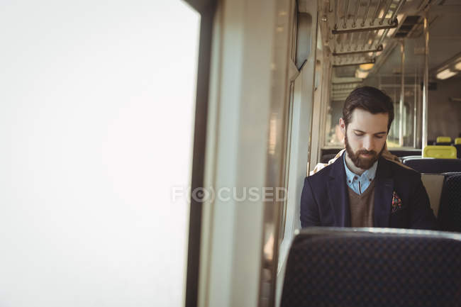 Jeune homme d'affaires voyageant en train — Photo de stock