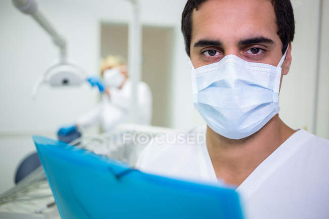 Retrato de dentista en máscara quirúrgica en clínica dental - foto de stock