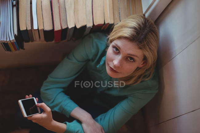 Портрет красивой женщины с помощью мобильного телефона дома — стоковое фото