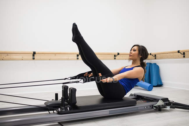 Mitte erwachsene Frau trainiert im Fitnessstudio auf Reformer — Stockfoto