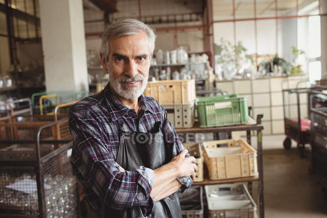 Портрет стеклодува, стоящего со скрещенными руками на стеклодувном заводе — стоковое фото