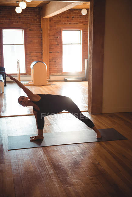Woman practicing yoga pose in fitness studio — Stock Photo