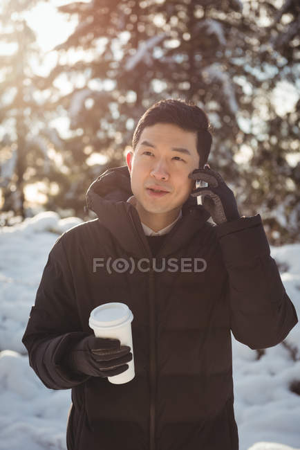 Людина в теплому одязі розмовляє на мобільному телефоні взимку — стокове фото