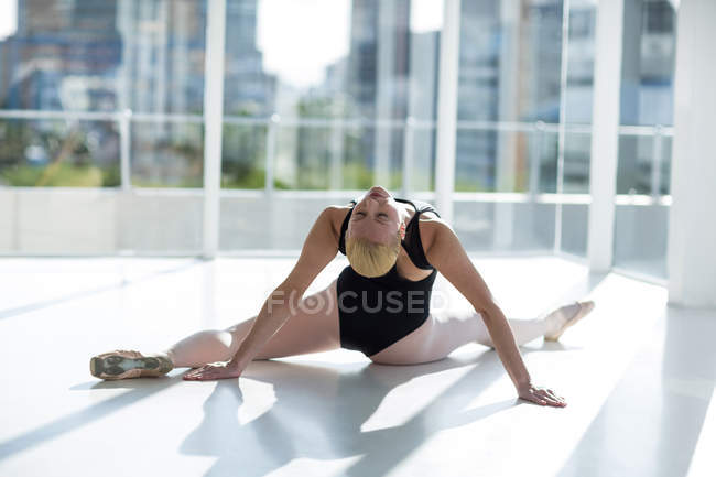 Bailarina haciendo ejercicio de estiramiento en el estudio de ballet - foto de stock