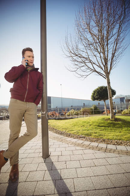 Молодий чоловік розмовляє по мобільному телефону на вулиці в місті — стокове фото