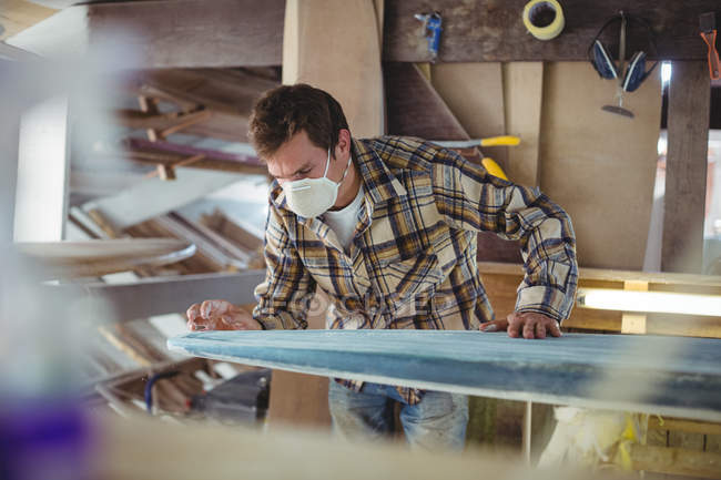 Mann bastelt Surfbrett in Werkstatt — Stockfoto