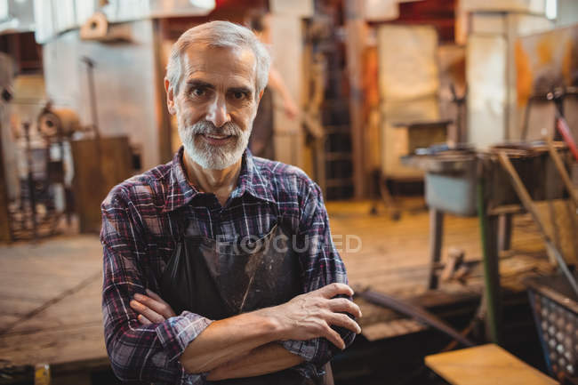 Retrato de soprador de vidro em pé com os braços cruzados na fábrica de sopro de vidro — Fotografia de Stock