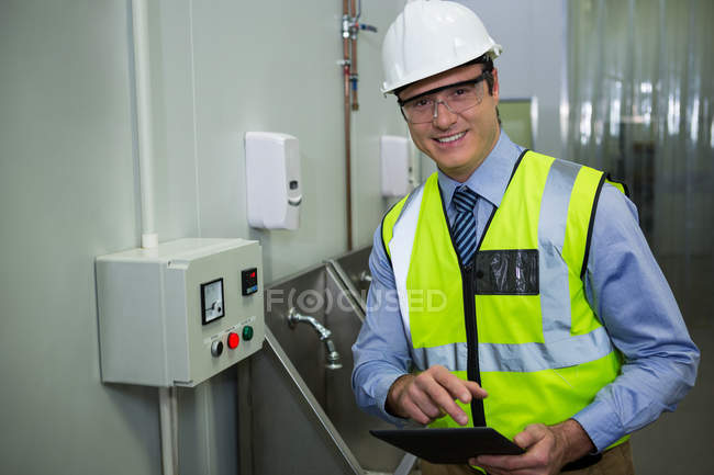 Technician holding digital tablet at meat factory — Stock Photo