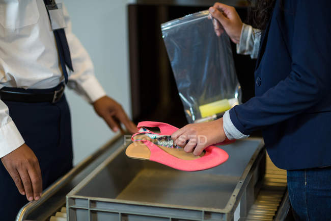Mid-section of commuter collecting accessories from crate in airport — Stock Photo