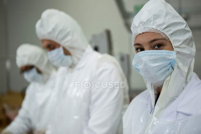 Close-up de açougueiros usando máscaras na fábrica de carne — Fotografia de Stock