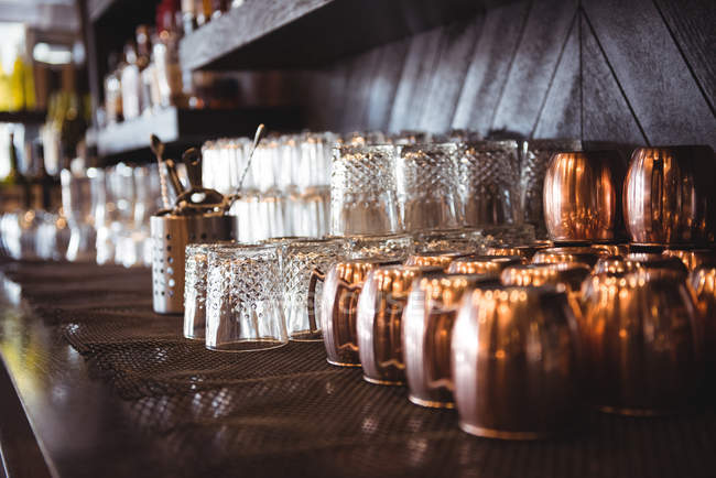 Gros plan de verres vides disposés sur une étagère dans un bar — Photo de stock