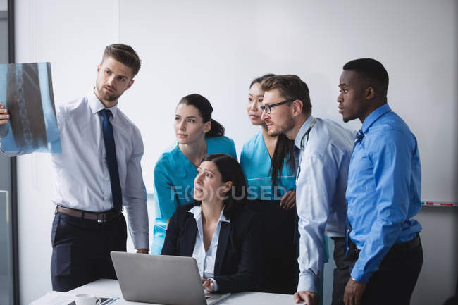 Medical team examining an x-ray report in conference room — Stock Photo