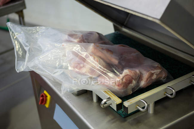 Close-up da máquina de embalagem a vácuo na fábrica de carne — Fotografia de Stock