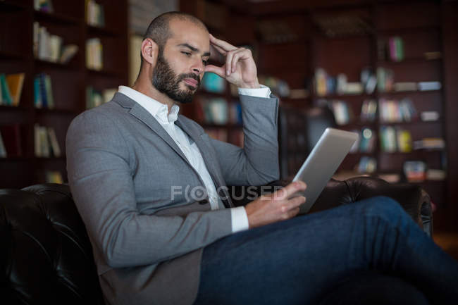 Businessman using digital tablet in waiting area at airport terminal — Stock Photo