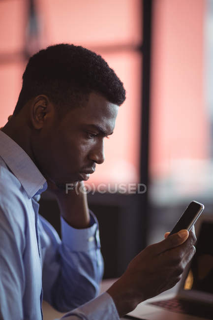 Businessman using mobile phone in office — Stock Photo