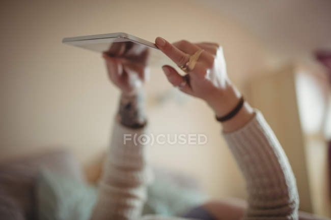 Woman using digital tablet on bed at home — Stock Photo