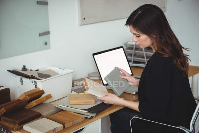 Business executive looking at stone slab in office — Stock Photo