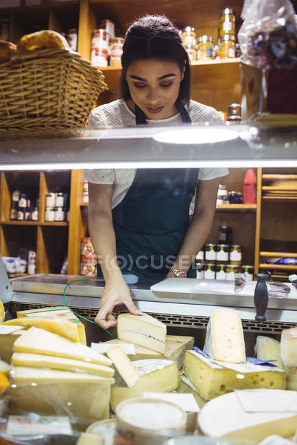 Female staff working at cheese counter in supermarket — Stock Photo